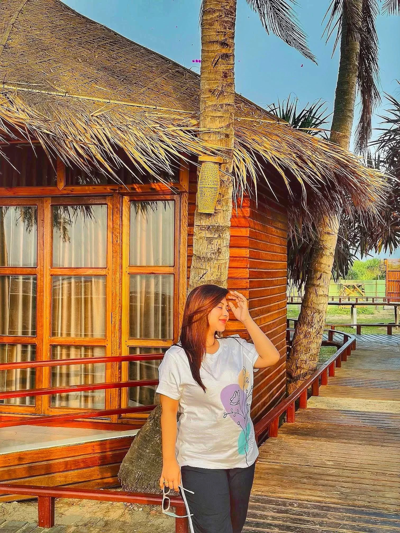 Wooden villa exterior among palm trees at LuiPaz Resort