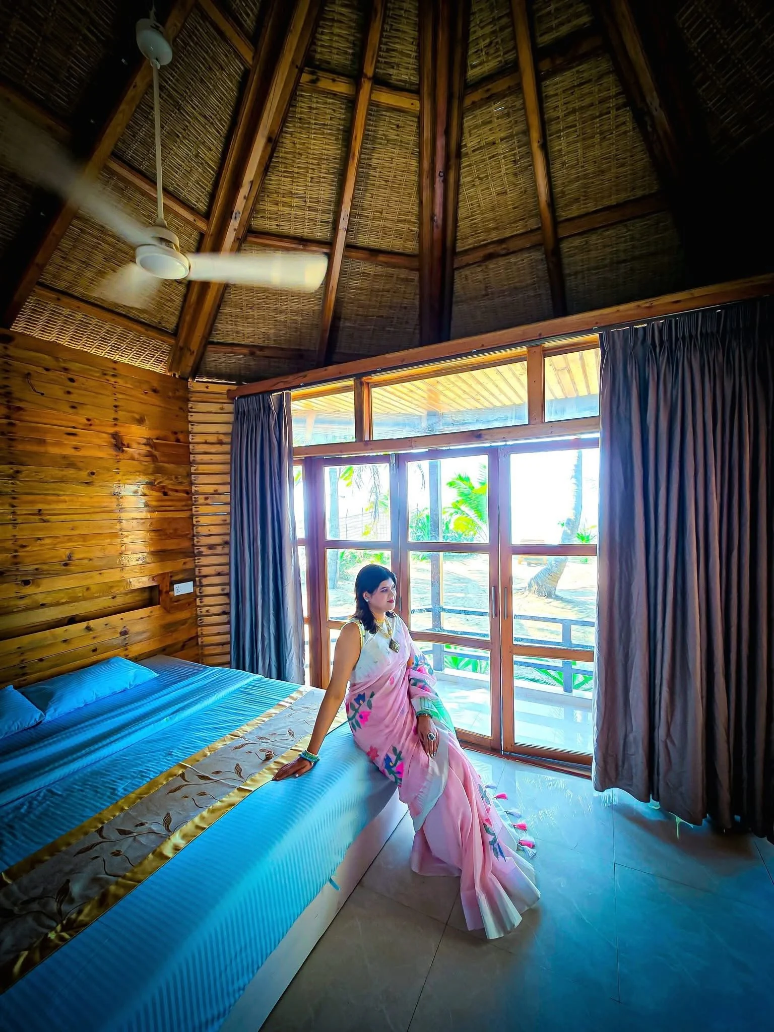 A wooden room at LuiPaz Resort with a bed and large seaside windows